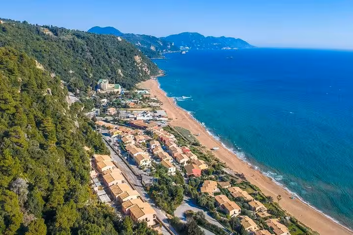 Aerial view of Glyfada Beach coastline and seaside village on Corfu private beach tour to top beaches