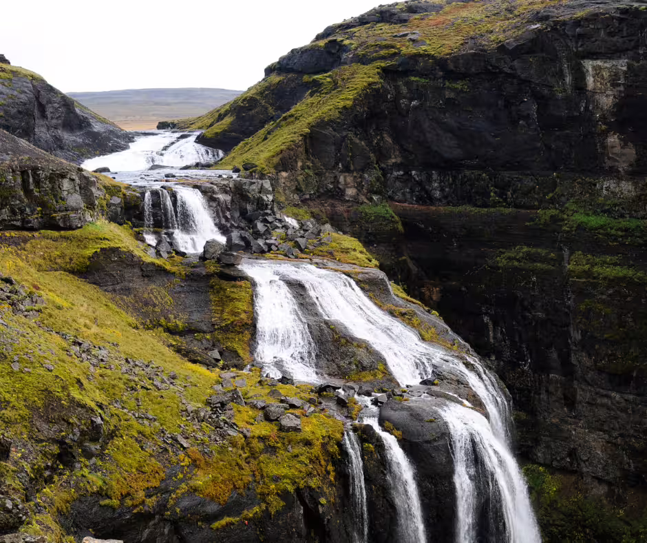 Glymur waterfall cascading over mossy volcanic rock cliffs in Iceland
