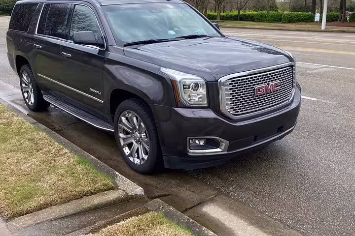 Dark gray GMC Yukon Denali XL SUV parked on street for private airport transfer service