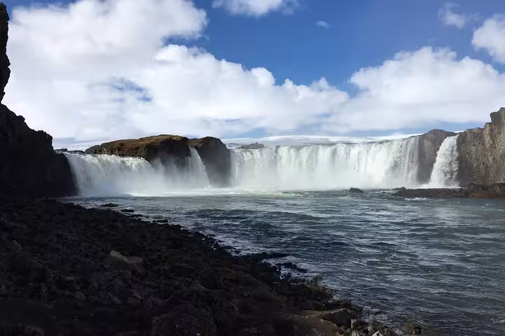 Scenic panorama of Godafoss Waterfall with misty cascades, perfect for an Akureyri day tour adventure.