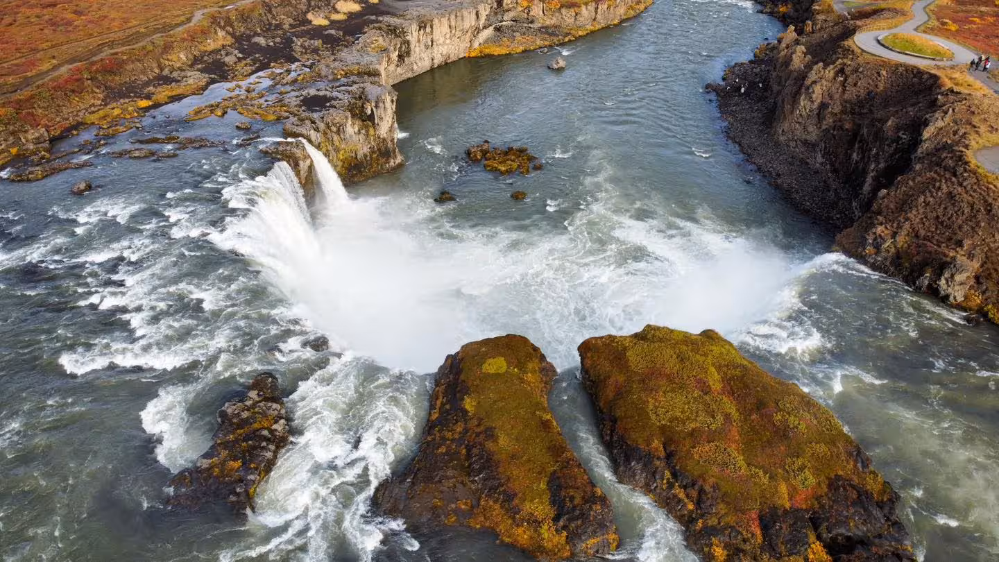Aerial view of Godafoss waterfall in Iceland with mossy rocks and autumn landscape
