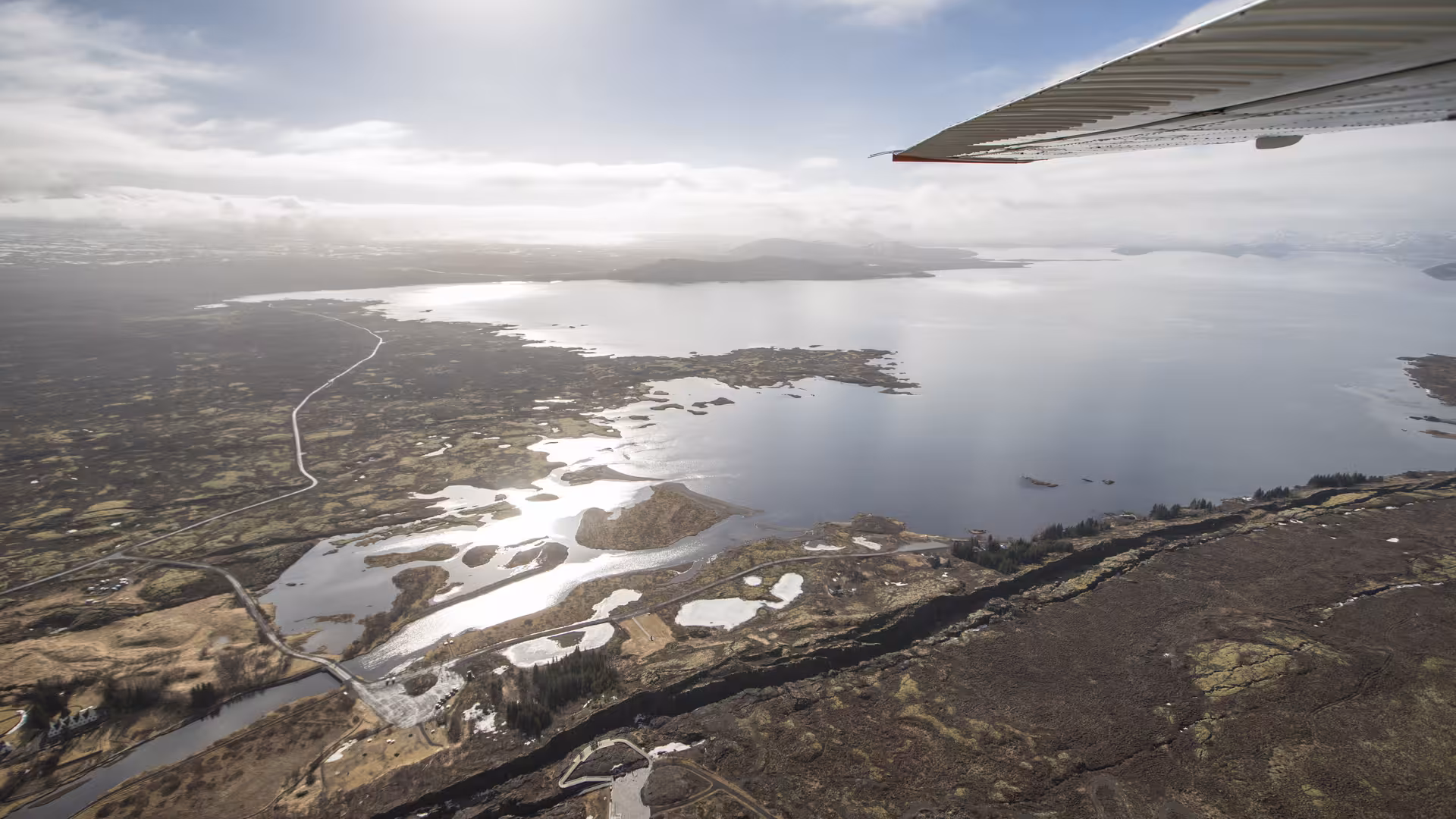 Aerial view from airplane wing over Þingvellir lake and tectonic rift, Golden Circle Iceland