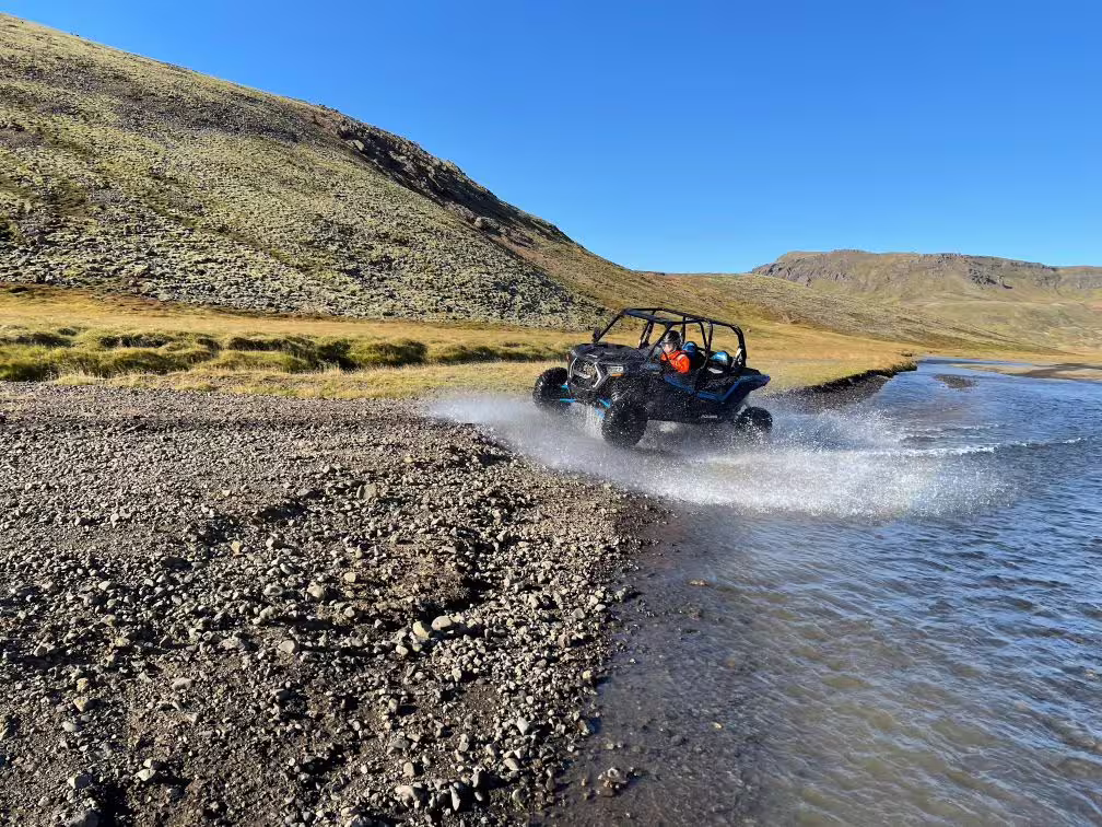 Blue Polaris buggy splashing through a river crossing on Iceland's Golden Circle tour
