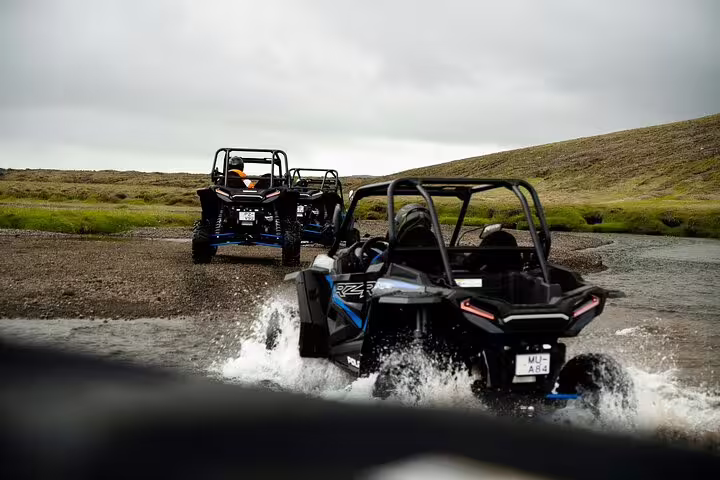 Two Polaris RZR buggies crossing a shallow river stream on the Golden Circle tour in Iceland