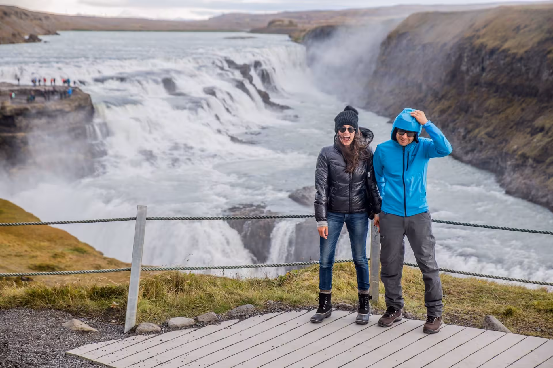 Couple smiling at Gullfoss waterfall viewpoint during a full-day private Golden Circle tour in Iceland