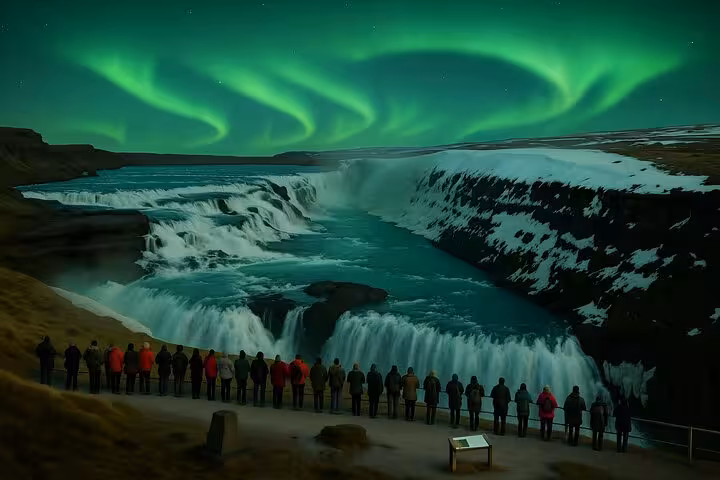 Tourists viewing Gullfoss waterfall under vibrant green northern lights on Iceland Golden Circle tour
