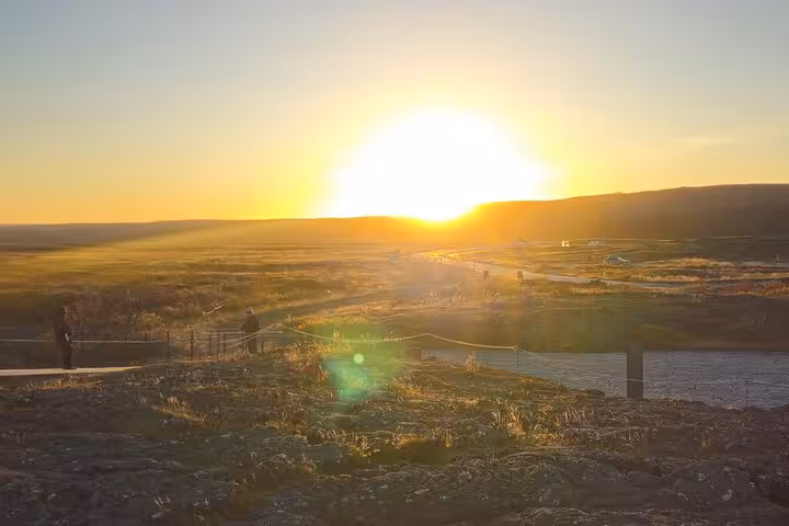 Golden sunset over Iceland's Golden Circle landscape with vast plains and winding road