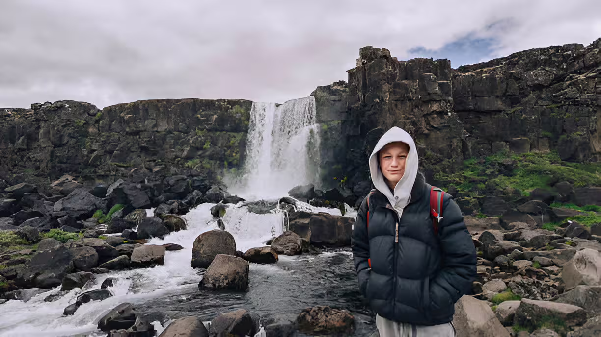Young traveler standing before Öxará waterfall on Iceland's Golden Circle tour