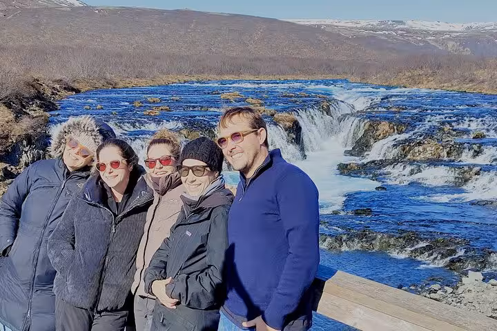 Five tourists posing at Bruarfoss waterfall on Golden Circle tour from Reykjavik, Iceland