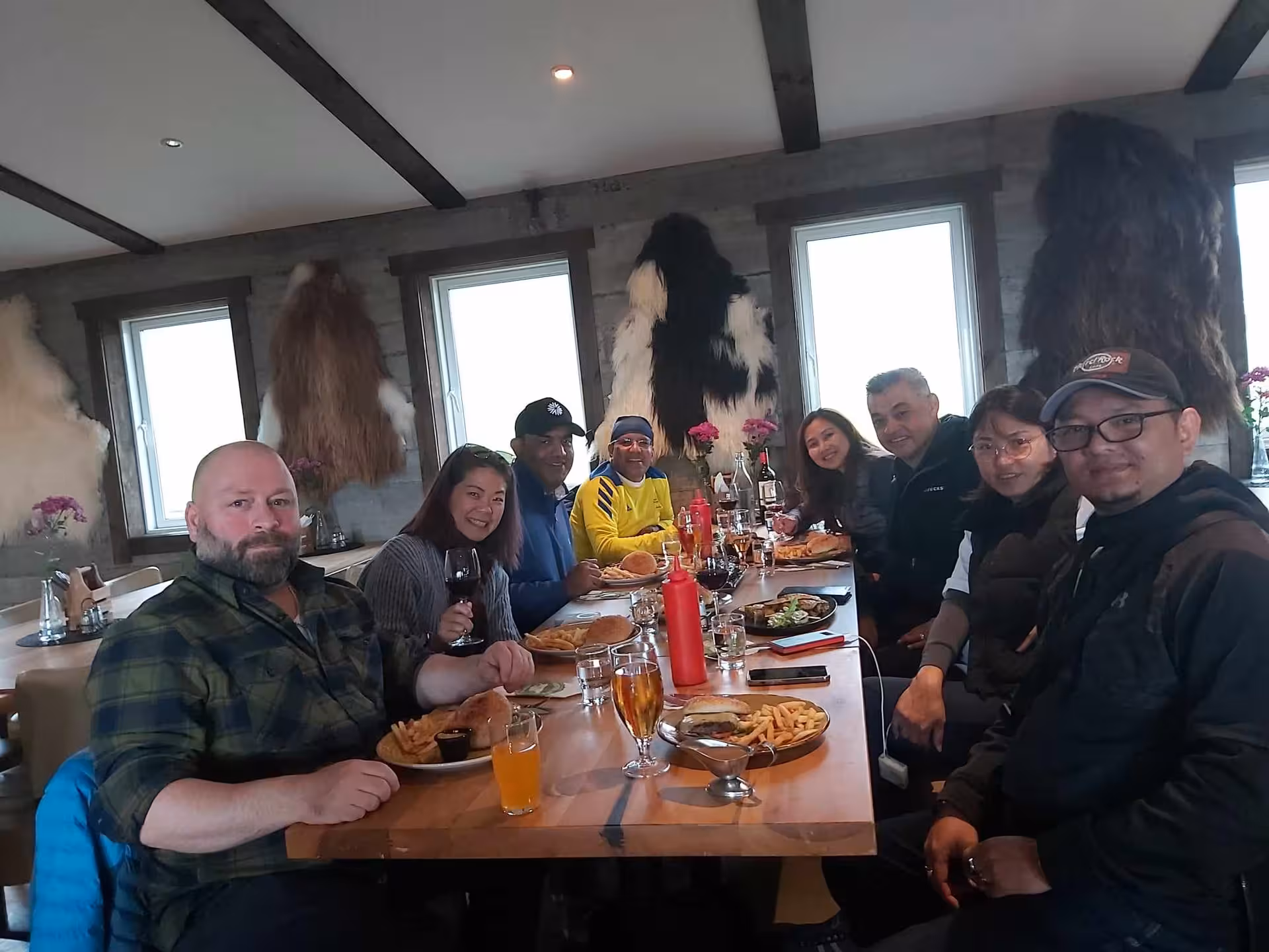 Group of tourists enjoying lunch together at a rustic Icelandic farm restaurant during a Golden Circle tour