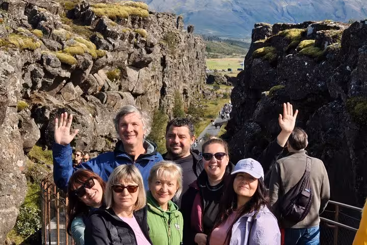 Group of tourists waving at Þingvellir canyon on Golden Circle tour from Keflavik Airport