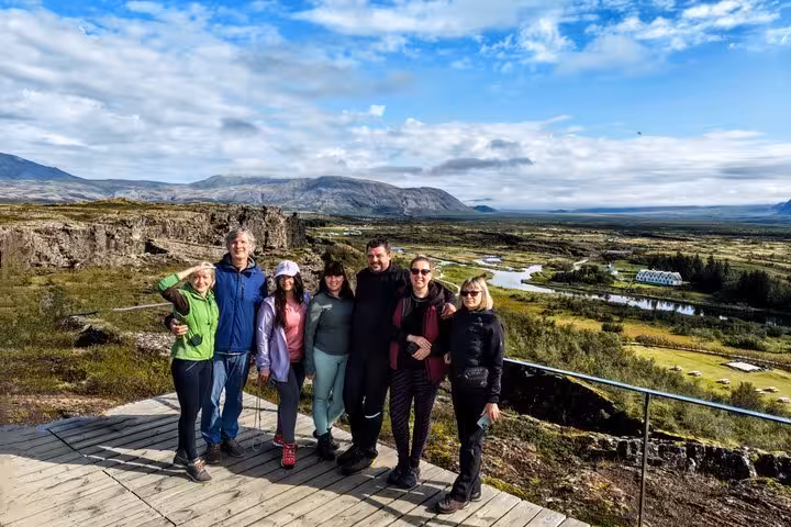 Group of seven tourists posing at Þingvellir National Park viewpoint on Golden Circle tour from Keflavik