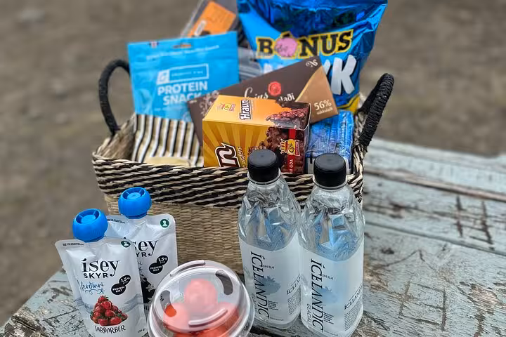 Welcome basket with Icelandic water bottles, skyr pouches, protein snacks and chocolate for Golden Circle tour