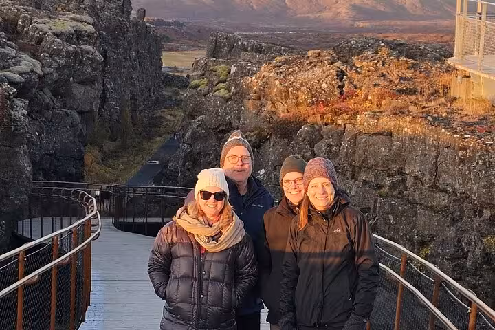 Four tourists posing on a walkway at Þingvellir National Park during Golden Circle tour in Iceland