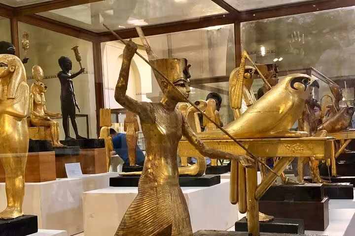 Golden ancient Egyptian statues inside the Grand Egyptian Museum, highlight of VIP Giza Pyramids tour
