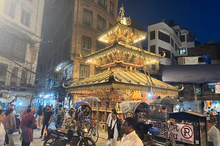 Illuminated golden Hindu temple glowing at night in Kathmandu Durbar Square during a self-guided GPS walking tour