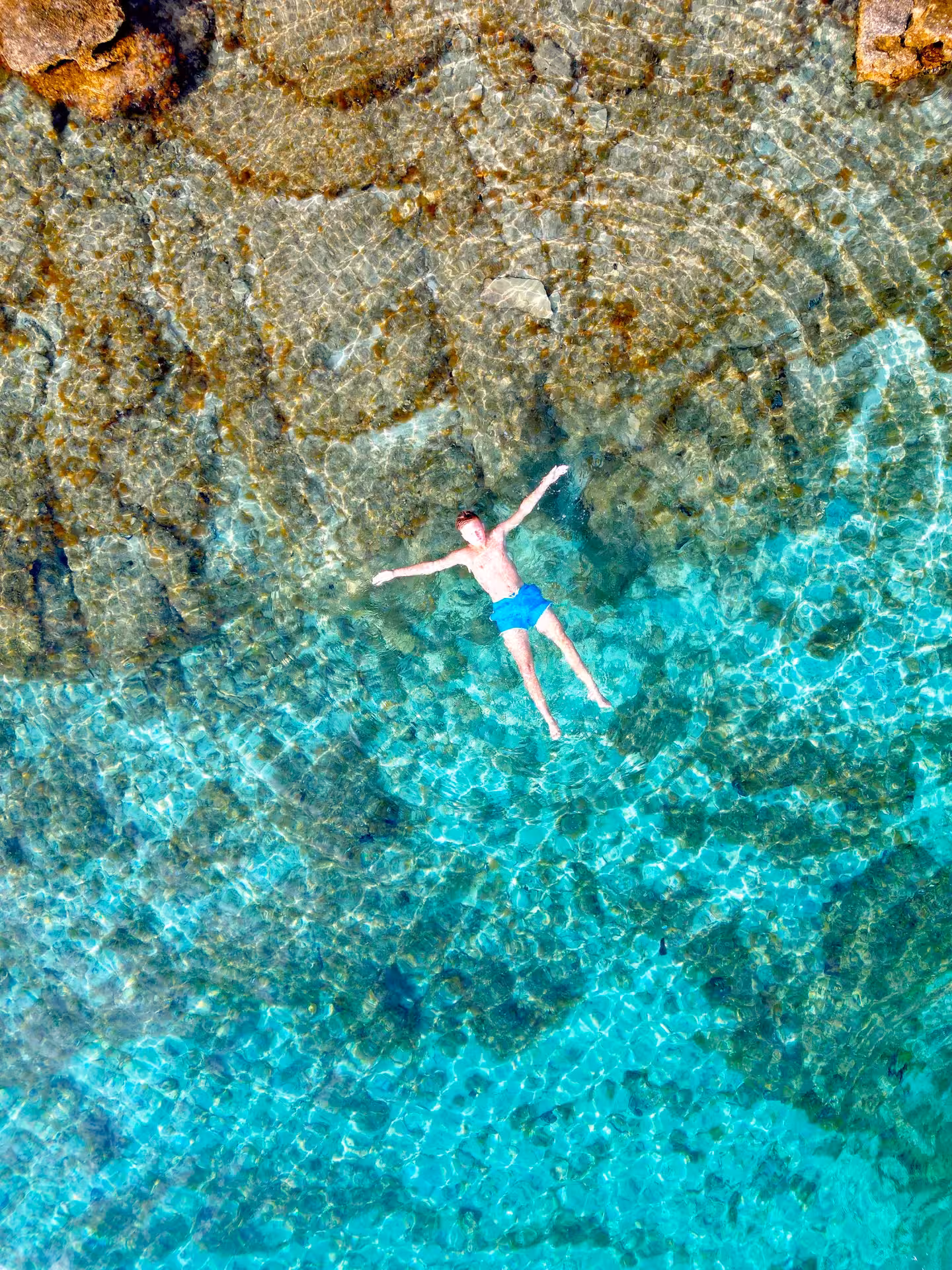 Aerial view of swimmer in turquoise Adriatic on 3 Islands tour to Golden Horn Beach, Blue Lagoon and Jelsa