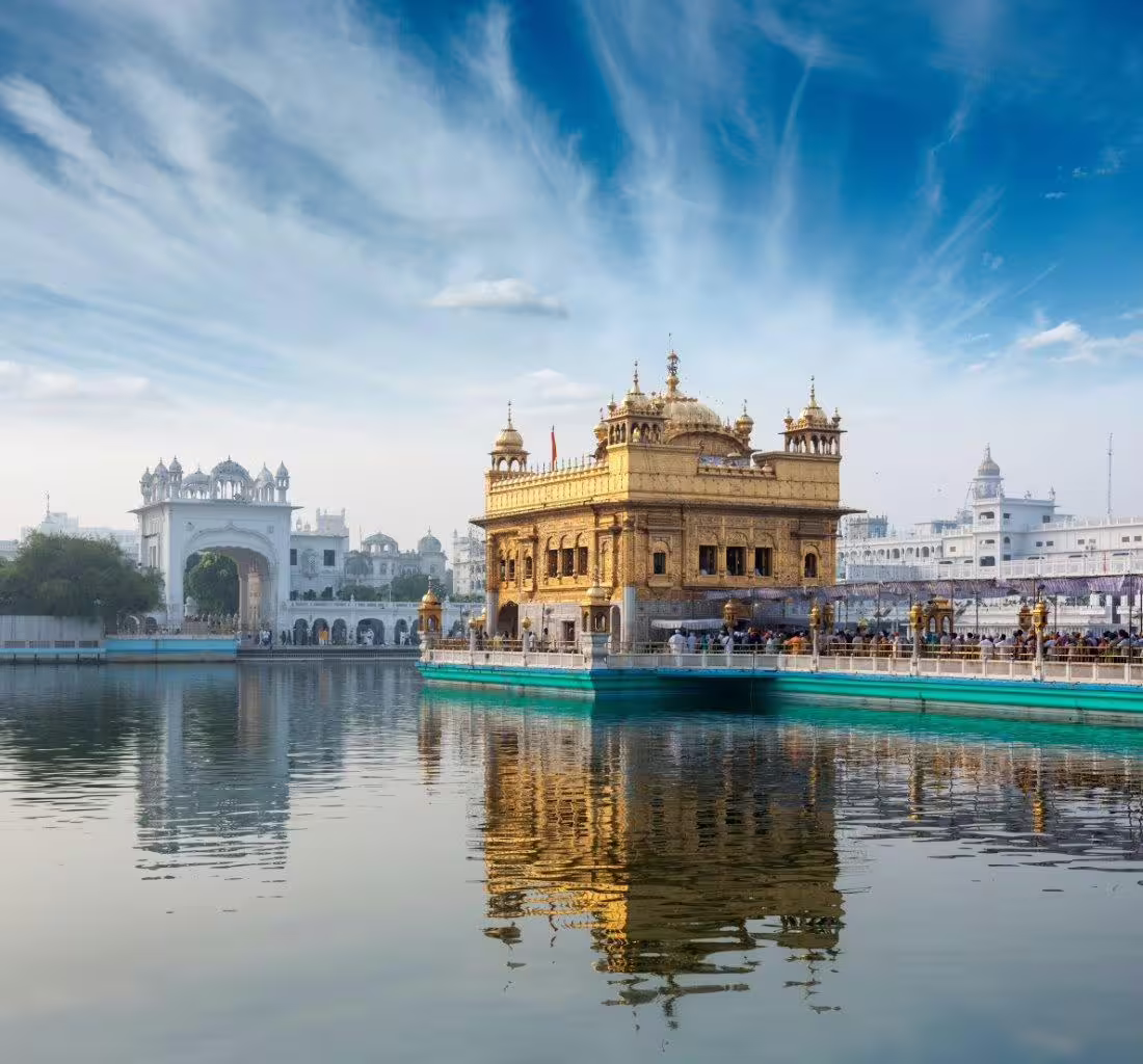 Golden Temple in Amritsar captured in daylight, with its stunning architecture mirrored in the serene water, key attraction in India tour.