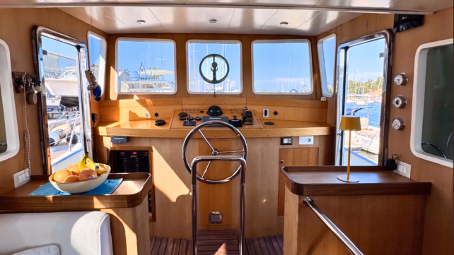 Interior of a boat's helm featuring a steering wheel and large windows, ideal for Golfo Aranci tours to Tavolara and Molara.