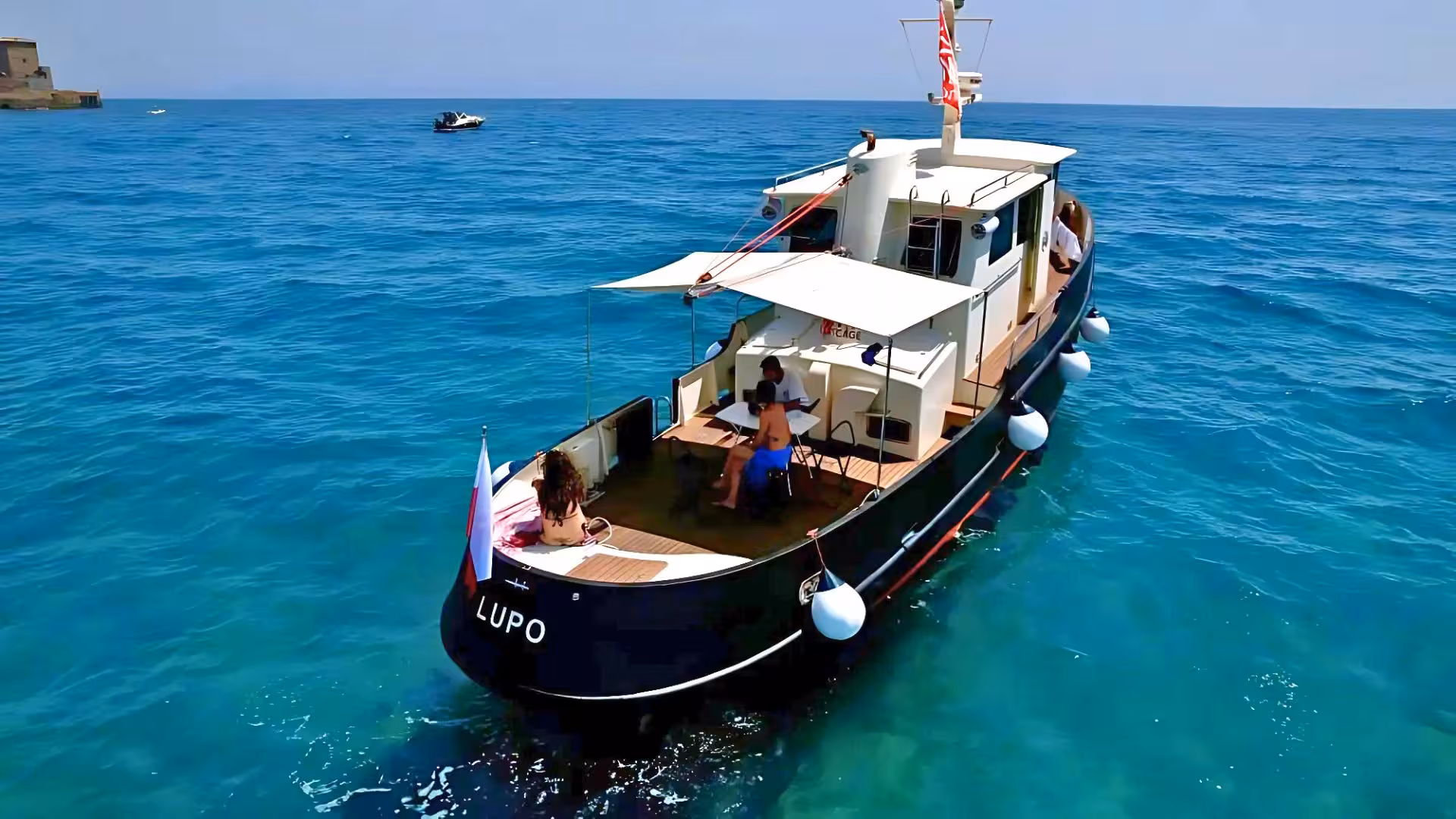 Boat cruising near Golfo Aranci with passengers enjoying the sun, ideal for Tavolara, Molara, and Figarolo boat tours.