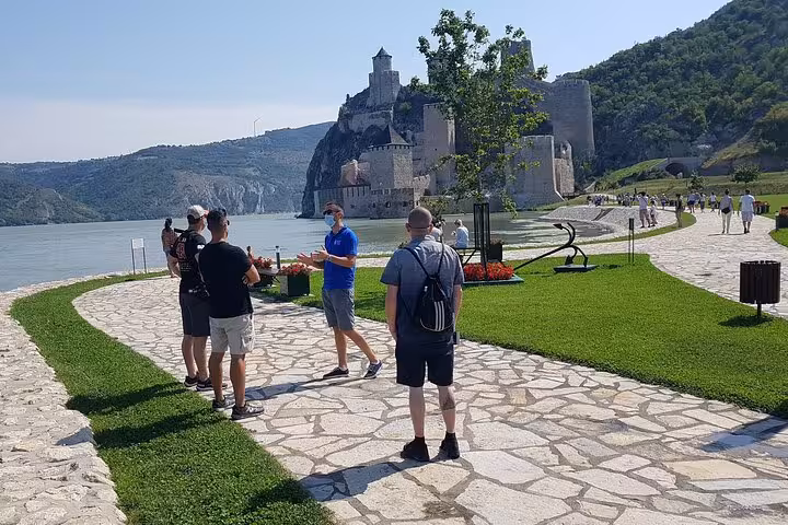 Tourists exploring the historic Golubac Fortress by the Danube River, a highlight of the Iron Gate Gorge day trip from Belgrade.