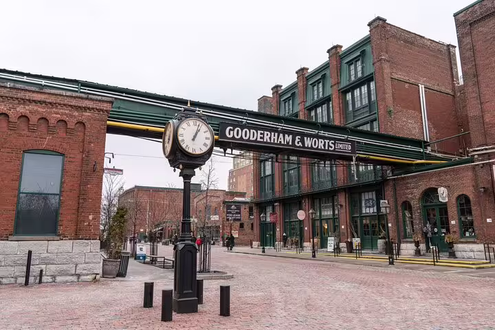 Gooderham & Worts sign on historic brick buildings with street clock in Toronto Distillery District