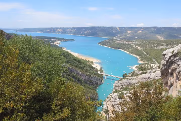 Turquoise waters of Lac de Sainte-Croix with rocky cliffs and bridge at Gorges du Verdon, France