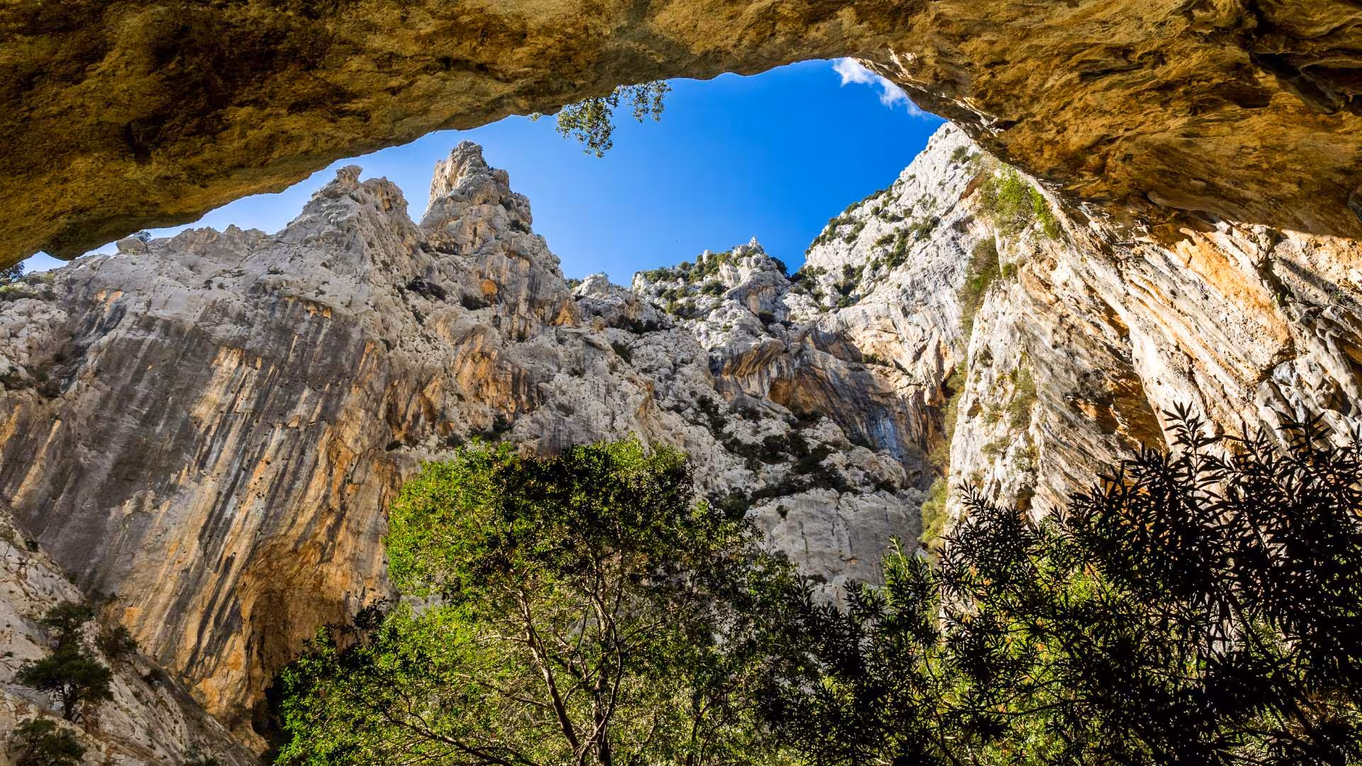 Discover breathtaking views of Gorropu Canyon's rocky formations and lush greenery on this trekking adventure from Cala Gonone.