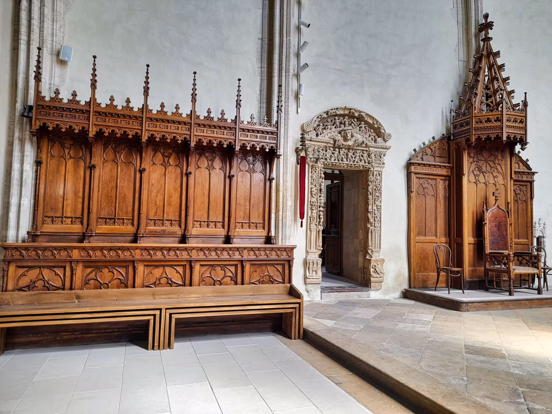Ornate Gothic wooden choir stalls and carved stone portal inside a historic Cluj church on a guided history walking tour