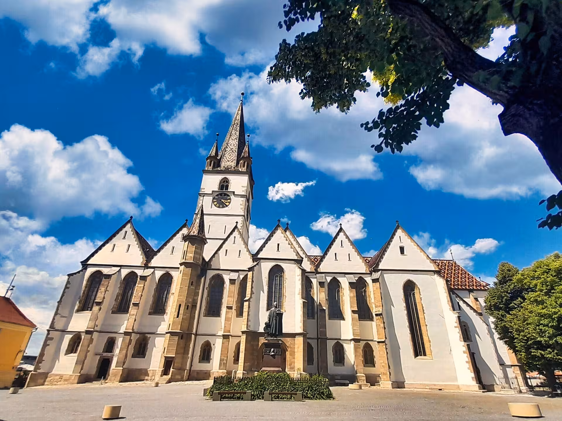 Gothic Lutheran Cathedral of Saint Mary in Sibiu with tall spire under blue sky on Cluj-Napoca day trip