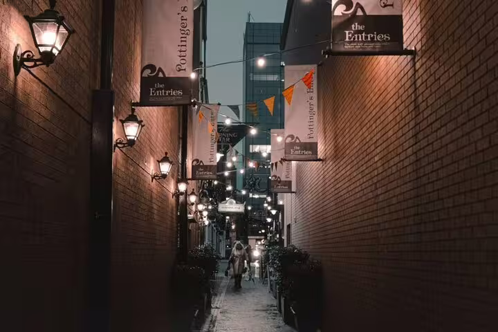 Narrow lantern-lit alley with brick walls and hanging signs at night