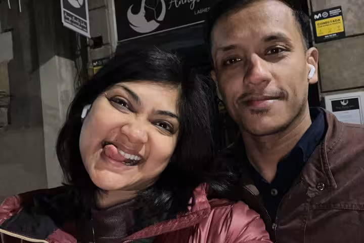 Two smiling visitors posing together at night in Barcelona's Gothic Quarter