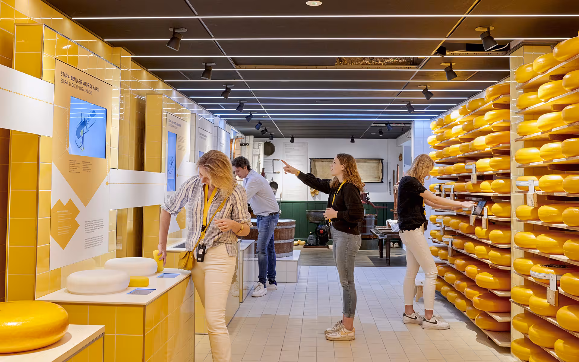 Gouda cheese experience with stacked wheels and visitors, tasting stop on private tour from The Hague/Leiden