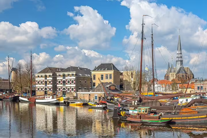Gouda harbor canal with traditional boats and skyline, scenic highlight on the self-guided GPS audio tour