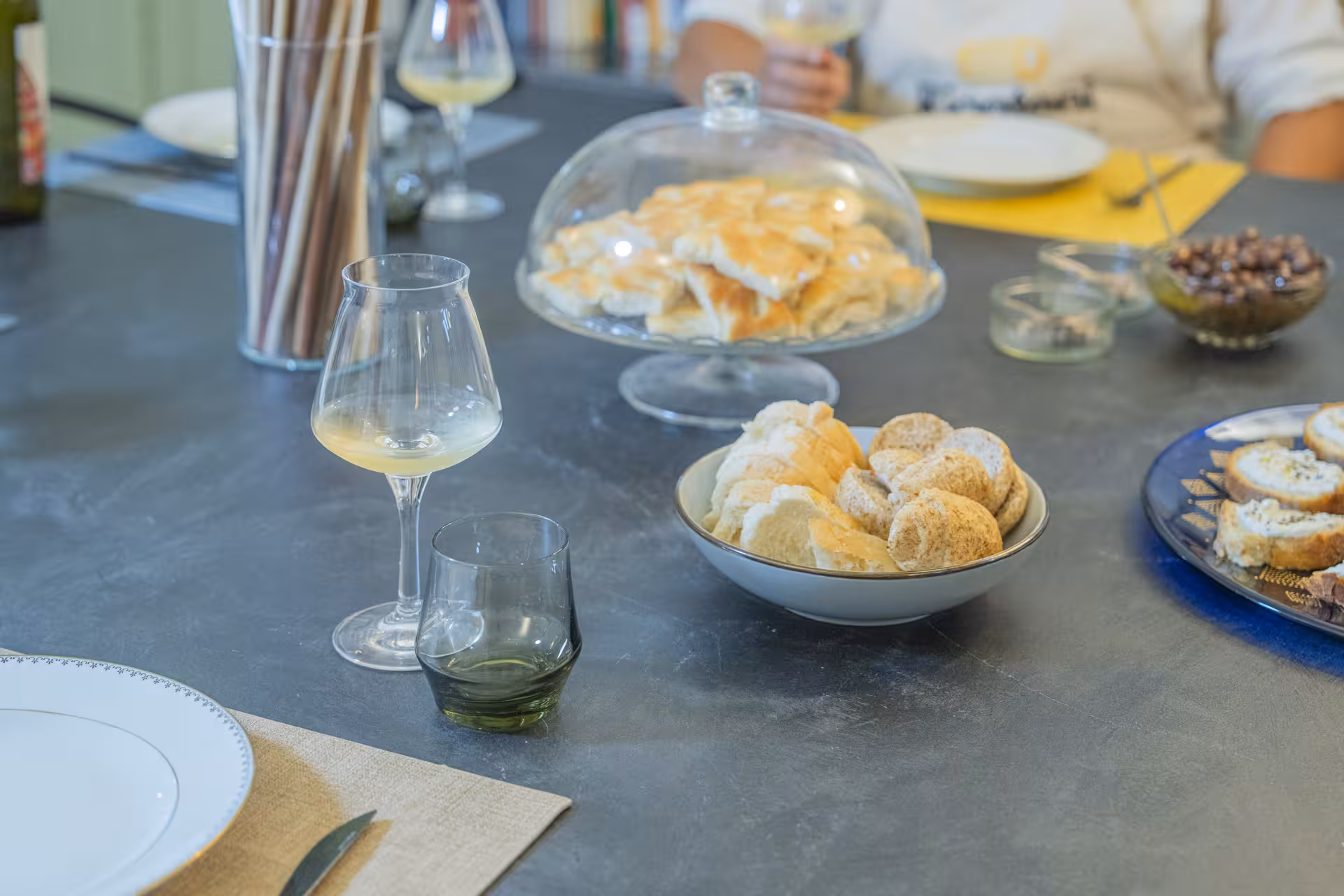 Close-up of gourmet appetizers and wine glasses on a table set for an exclusive private dinner experience.