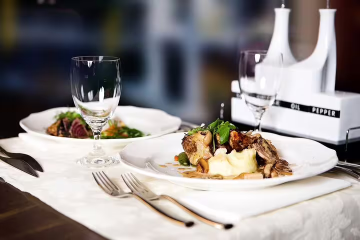 Elegant table setting with gourmet dishes and wine glasses on a 3-hour food and drink culinary tour.