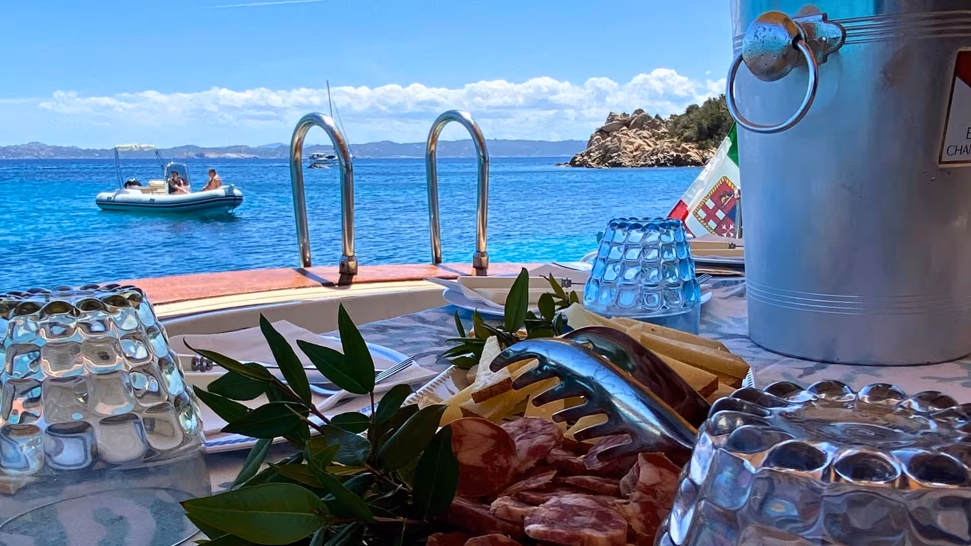 Gourmet spread on a boat overlooking the stunning waters of La Maddalena in southern Corsica.