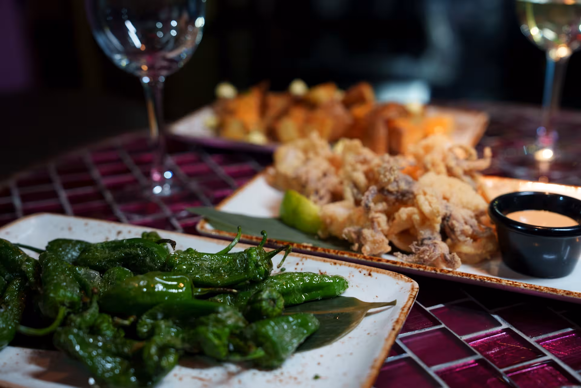 Gourmet tapas selection with padrón peppers and calamari, perfect for a flamenco night.