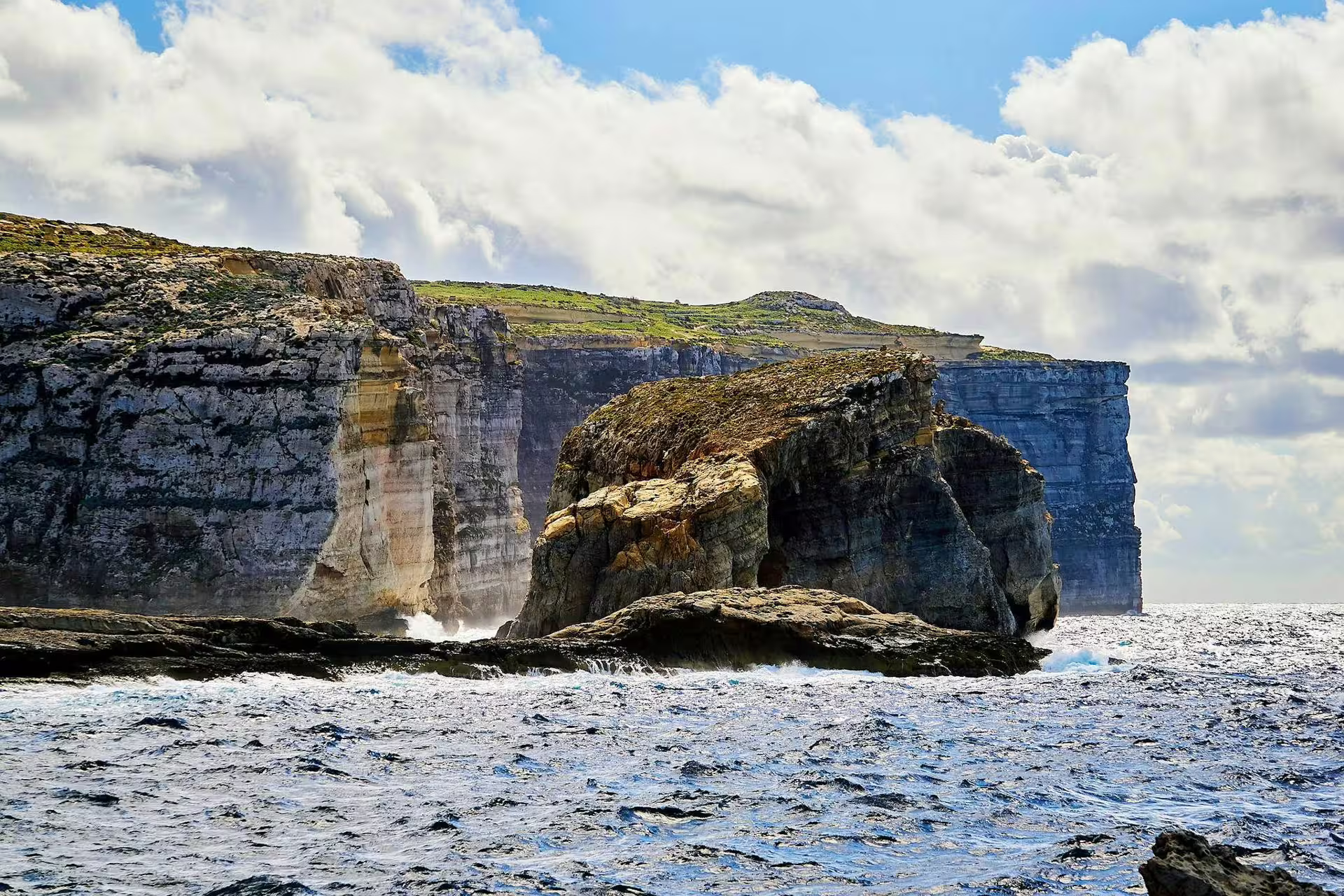 Dramatic Gozo coastline cliffs and Fungus Rock rising from the Mediterranean Sea on a small group island tour