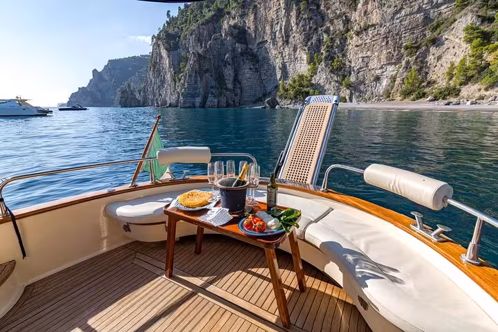 Luxurious Gozzo Apreamare 10 with a gourmet lunch set against stunning Capri cliffs on a private tour from Sorrento.