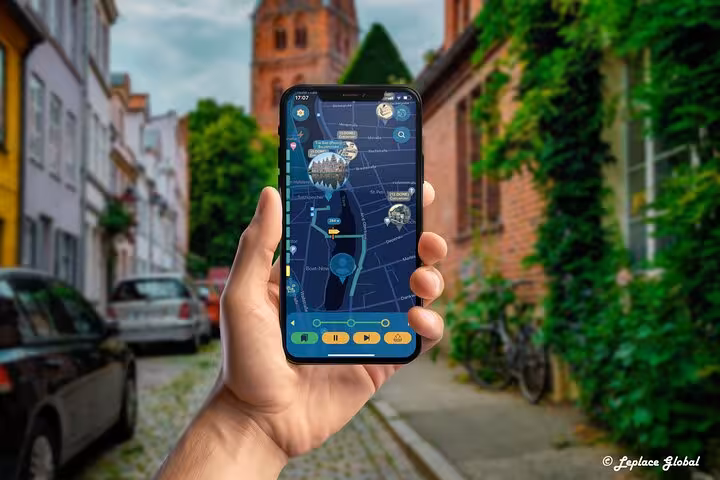 Hand holding smartphone with GPS ghost hunting tour app map in Lubeck's historic ivy-covered brick street alley