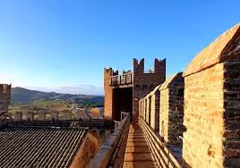 Sunlit Gradara Castle battlements and walkway, following Paolo and Francesca legend with Dante guide