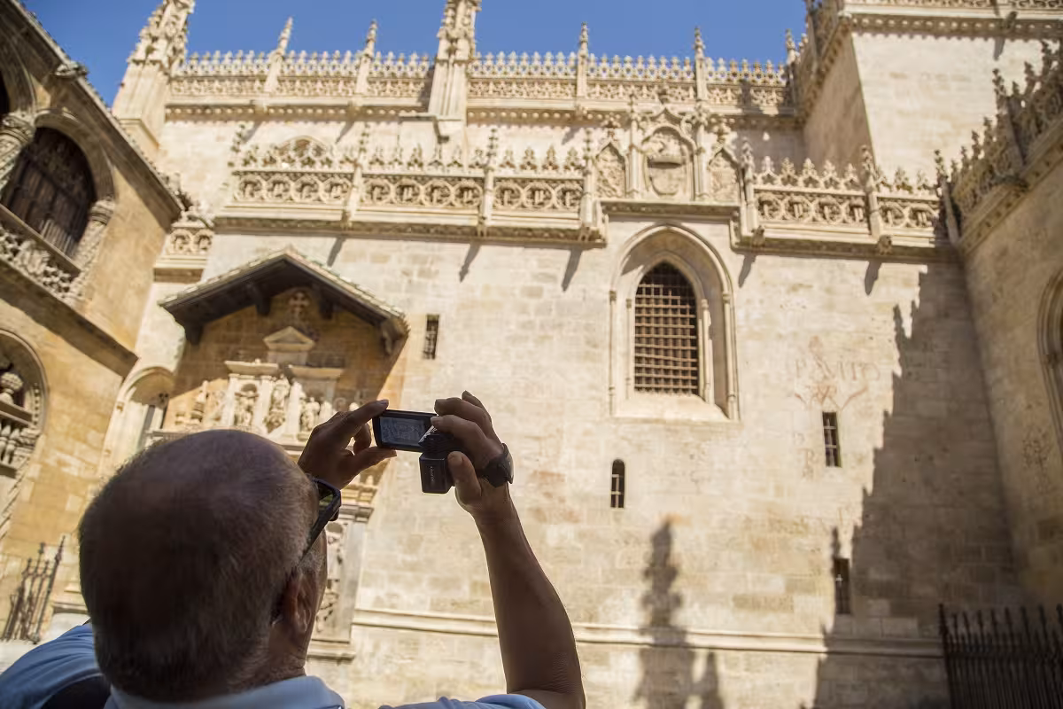 Visitor capturing the ornate facade of the Royal Chapel in Granada on a guided historic center tour.