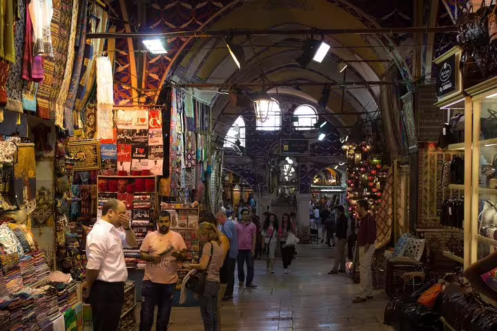 Grand Bazaar aisle with colorful textiles and shoppers, featured on Istanbul 7-hour tram tour saving time