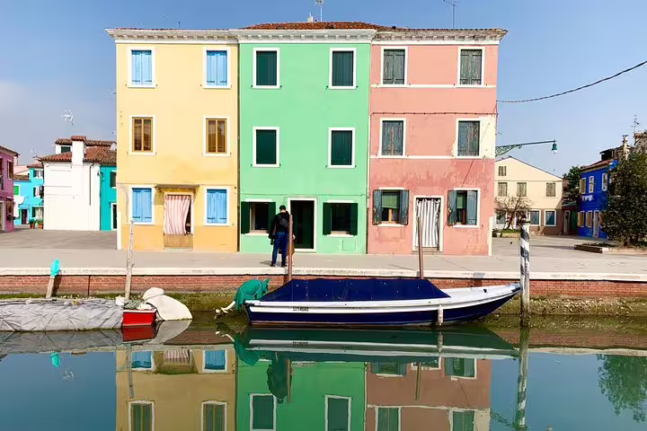Colorful Burano buildings reflected in the canal, ideal for a scenic Grand Canal Boat Private Tour experience.