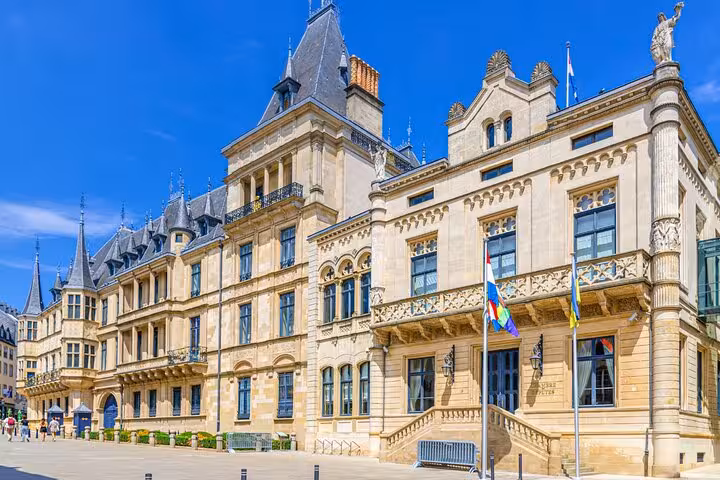 Grand Ducal Palace facade in Luxembourg City on a sunny day with colorful flags