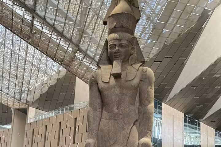 Colossal ancient Egyptian statue inside the Grand Egyptian Museum on a private Giza tour from Cairo