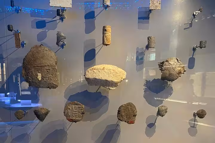 Ancient Egyptian stone tools and carved artifacts on display at the Grand Egyptian Museum day tour Cairo
