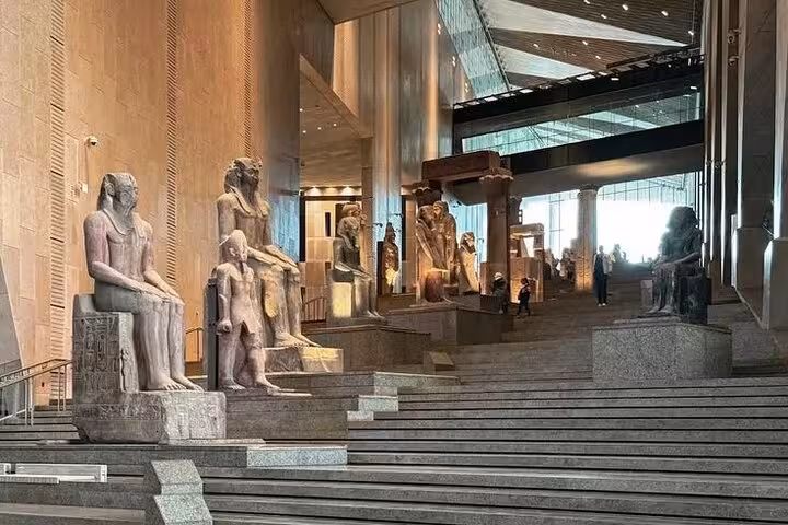 Grand Egyptian Museum atrium statues on staircase, key stop on expert female Egyptologist Cairo tour