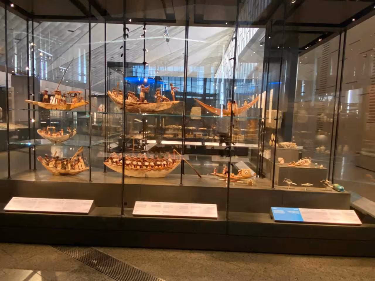 Grand Egyptian Museum gallery featuring ancient Egyptian boat models on full-day Giza Pyramids tour with lunch